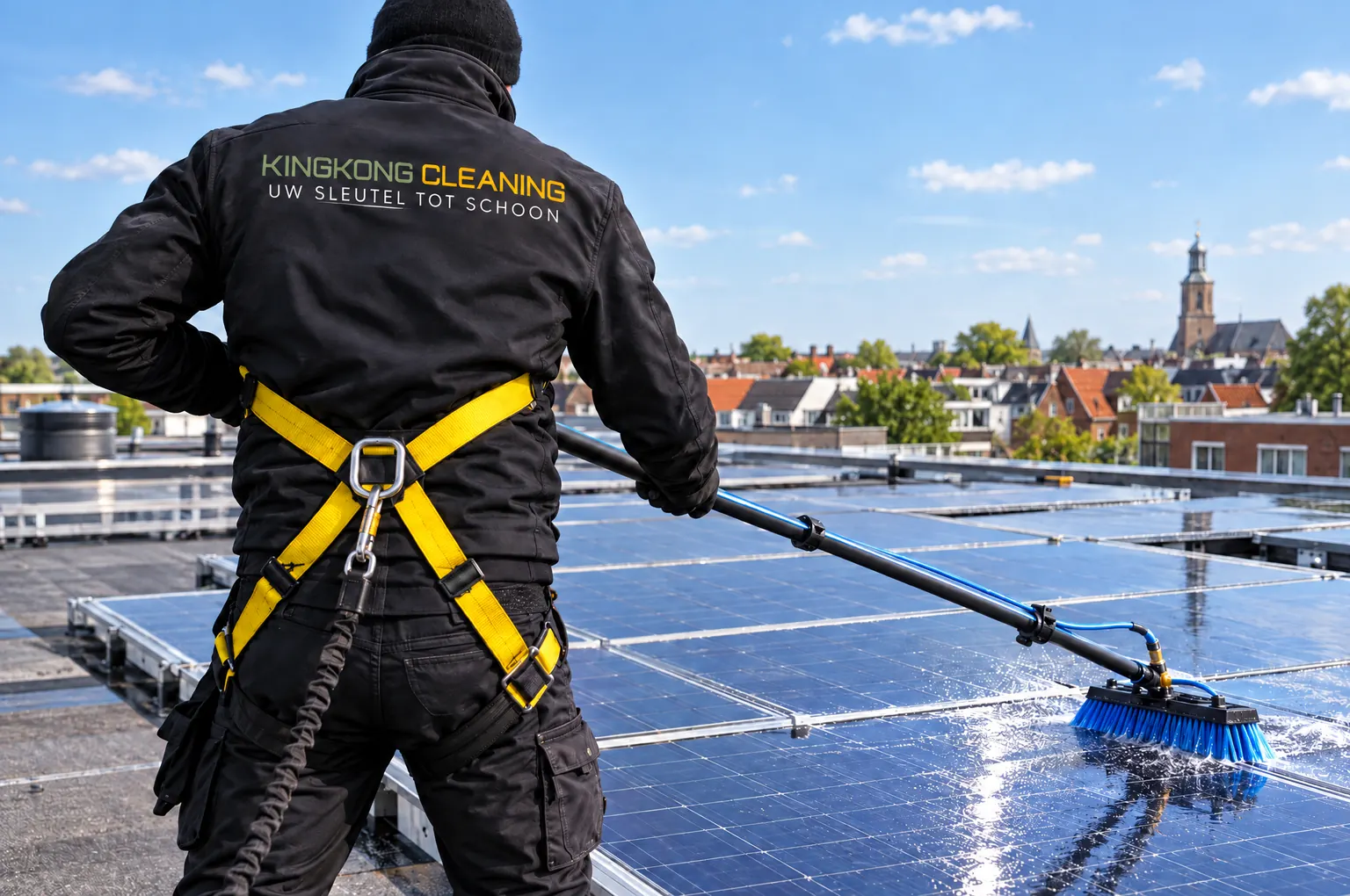 Medewerker van Kingkong Cleaning reinigt zonnepanelen op een dak
